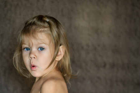 surprised little girl looking at camera with astonishmentの写真素材