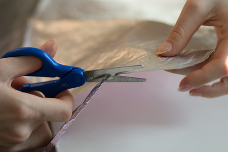 woman hands cutting paper with scissorsの写真素材