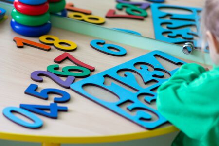 Child playing with multicolor wooden number puzzleの写真素材