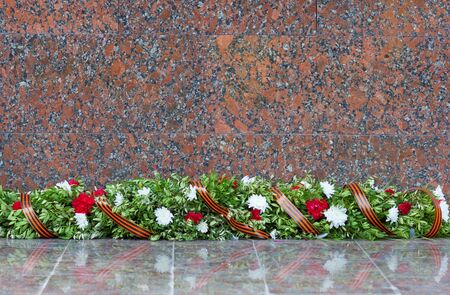 ommemorative wreath of flowers tied with St George ribbon at the foot of the monumentの写真素材