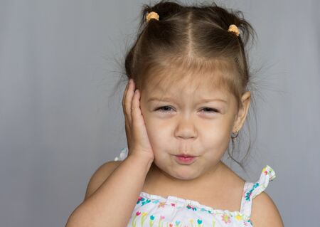 Portrait of little girl showing toothache on white backgroundの写真素材