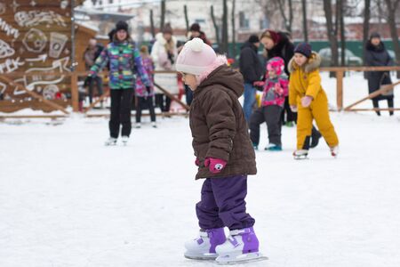 Side view of caucasian child of three years old skating on rink in wintertimeの写真素材