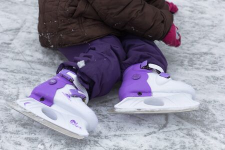 View of skates on rink on child legs in wintertimeの写真素材