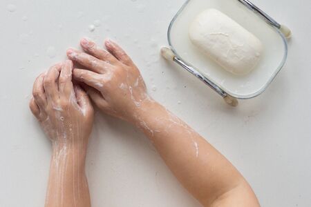 Top view of soaped child hands on the white backgroundの写真素材