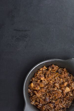 Top view of caramelized onion on black plate on the black backgroundの写真素材