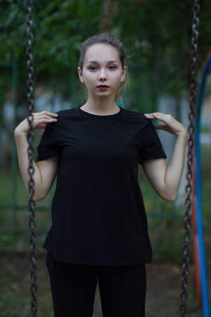 Young girl looking at camera holding her hand on shoulders in summertimeの写真素材