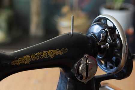 Machine pulley with wooden handle as part of old manual sewing machineの写真素材