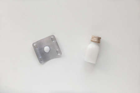 Top view of tablet for adult and tube for child with helminths medicine on white background