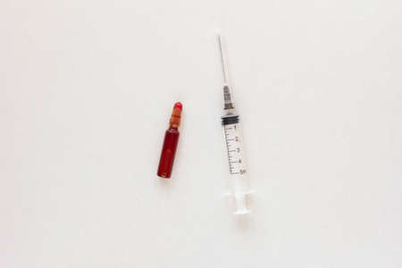 Top view of ampoule and syringe with vitamins group B for injection on the white backgroundの写真素材