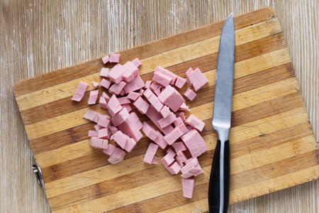 Top view of cutted sausage on the wooden cutting board and knifeの写真素材