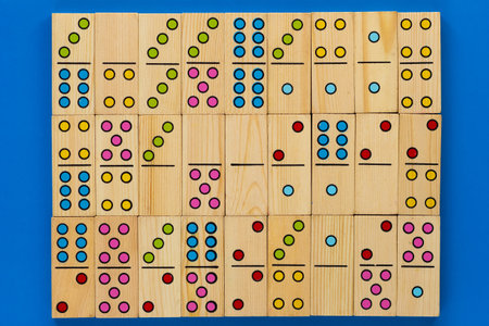 Top view of wooden dominoes gaming pieces as background on blue background