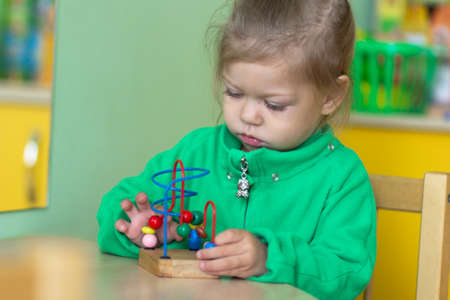 child playing with Bead Maze toy in kinder gardenの写真素材