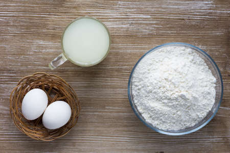 Whey, eggs and flour as ingredients for baking and cooking on the wooden backgroundの写真素材