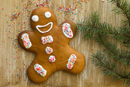 Baked decorated gingerbread cookie man on the wooden background