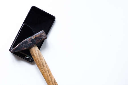 Broken touch mobile phone on the white background and hammerの写真素材