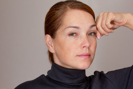 Portrait of woman with freckles looking at cameraの写真素材