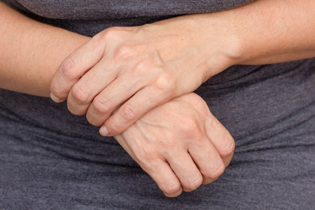 Woman hands showing right wrist pain over cropped body