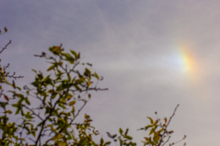 Little part of rainbow on blue skyの写真素材