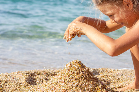 Caucasian child of 7 8 years playing with sand on sea beachの写真素材