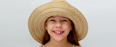 Portrait of caucasian smiling child in hat of 6 7 years looking at camera on white backgroundの写真素材
