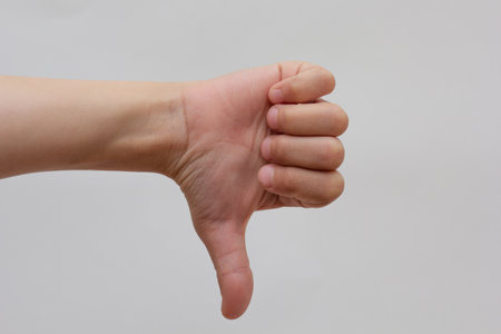 Child thumb down on white background