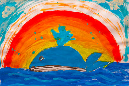 Whale in ocean under rainbow made by child using watercolor painting in naive styleの写真素材