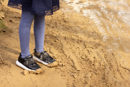 Child legs with shoes in mud outsideの写真素材