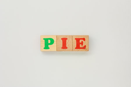 Bright wooden cubes arranged in sequence to create the word Pie on a white backdropの写真素材