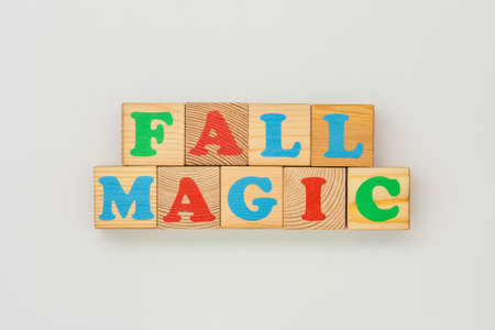 Wooden alphabet cubes with bright colors spelling Fall Magic