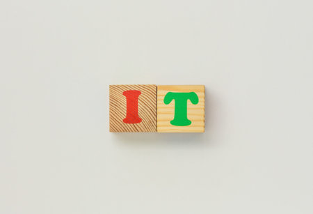 IT spelled with wooden blocks on white backgroundの写真素材