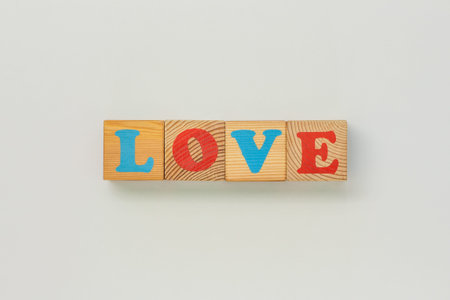 Love displayed with playful wooden letter cubes on white backgroundの写真素材