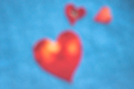 Blurred heart-shape red figure on blue background