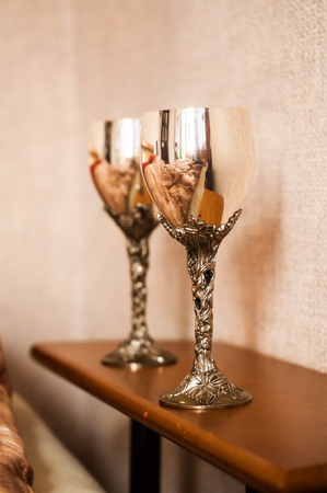 Two metal wineglasses with mirrored surface in the living room near bedの写真素材