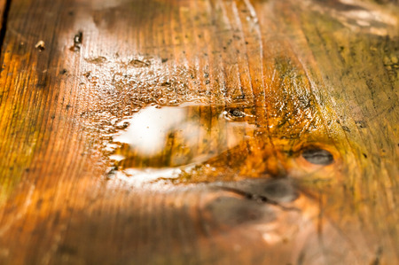 A puddle of water appeared after the rain on garden tableの写真素材