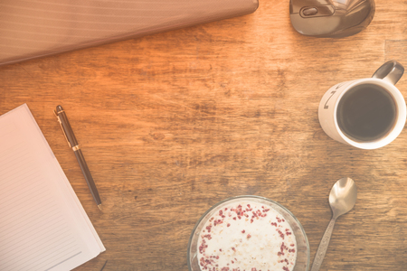 Notebook with pen, laptop, cup of coffee and plate of oat porridge. Concept of office break. Flat layの写真素材