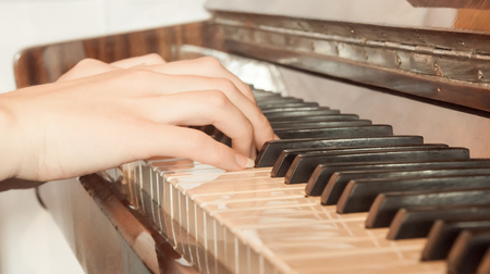 Young woman is playing the classical piano. Hands closeupの写真素材