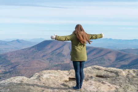 Young woman standing on the observation point on McAfee Knob in Virginia, USA