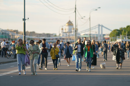 Moscow, Russia - June 4, 2021: People walk in public park in sunny summer day.Touristic and lifestyles concepts. Various generation and fashion stylies. Cathedral of Christ the Saviour in the distanceのeditorial素材