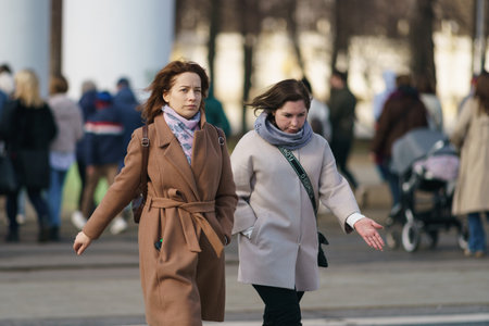 Moscow, Russia - March 28, 2023: Street photography. Youth on the city street in the spring day. Crossing the street. Lifestyle concept. Portraits of happy friends. Everybody glowing with happinessのeditorial素材