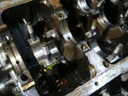 The connecting rod, piston and cylinder block in a disassembled condition in a car workshop.