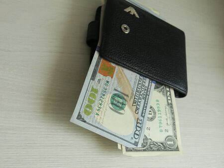 pulling focus on a folded and very used wallet with cards and cash inside on a table with a blurry...
