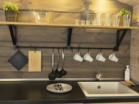 Interior of kitchen in rustic style with vintage kitchen ware and wooden wall.
