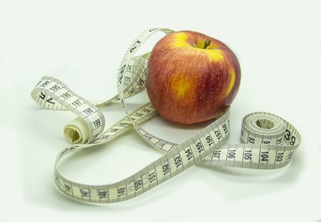 Diet concept with a red apple and measuring tape. Healthy foodの写真素材