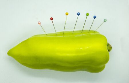 green bell pepper isolated on white background with few pin sticks