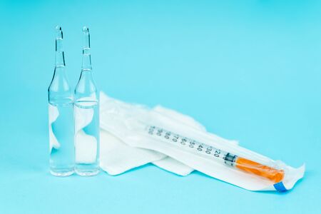 syringe and ampoule with vaccine lie on a blue backgroundの写真素材