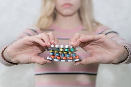 girl holds a lot of blisters with pills