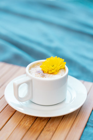 Cup of coffee with milk on a blue background with free space for textの写真素材