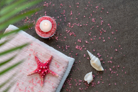 Starfish, seashells, terry towel and candle on the sand. Spa and wellness conceptの写真素材