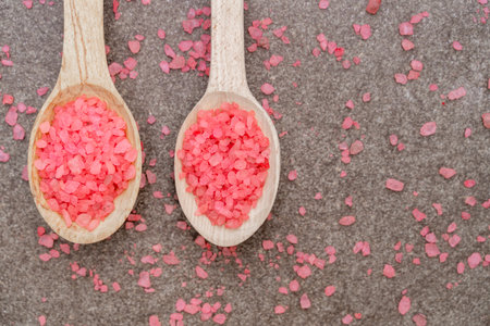 Two wooden spoons with pink sea salt close upの写真素材