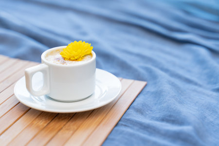 Cup of coffee with milk on a blue background with free space for textの写真素材